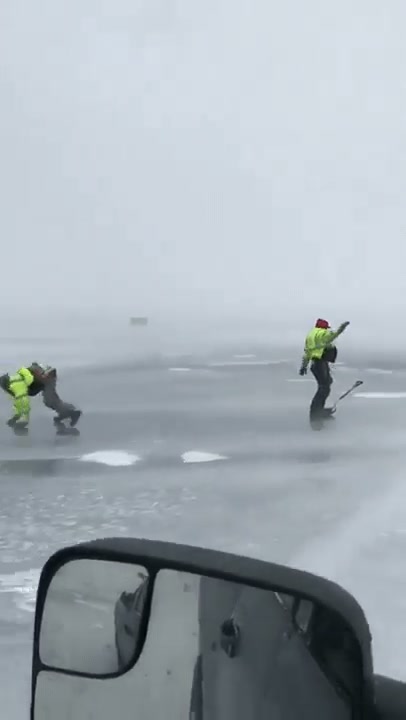 Man uses shovels and wind to surf on an icy lake