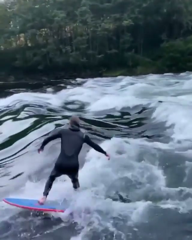 Surfing a river break in Norway